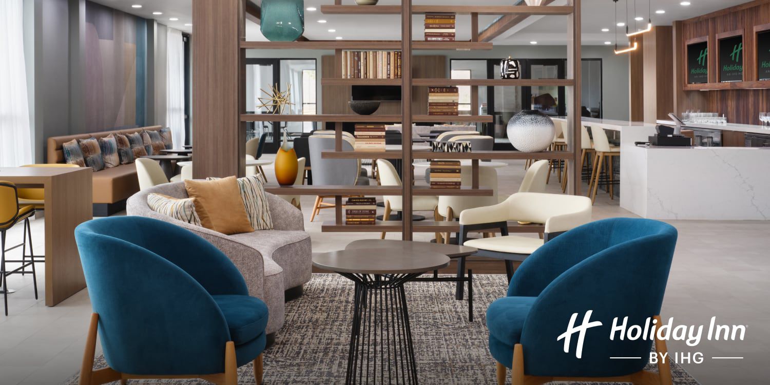 A modern hotel lobby with sleek furniture and spaces for relaxing and working.